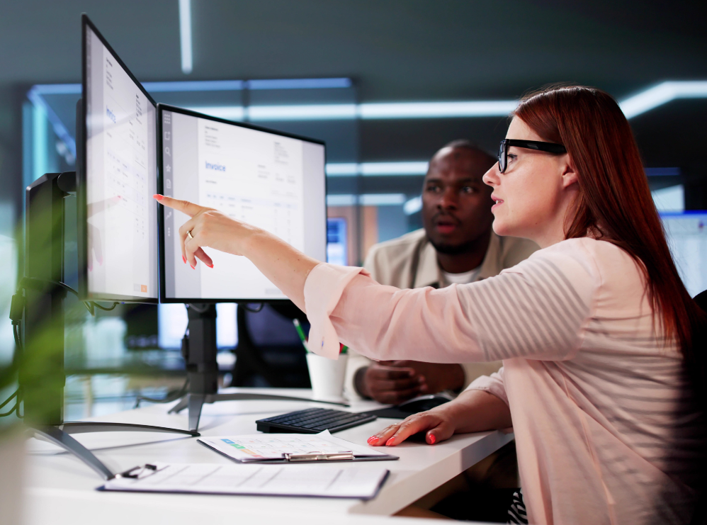 Two businesspeople examine reporting for online training data.